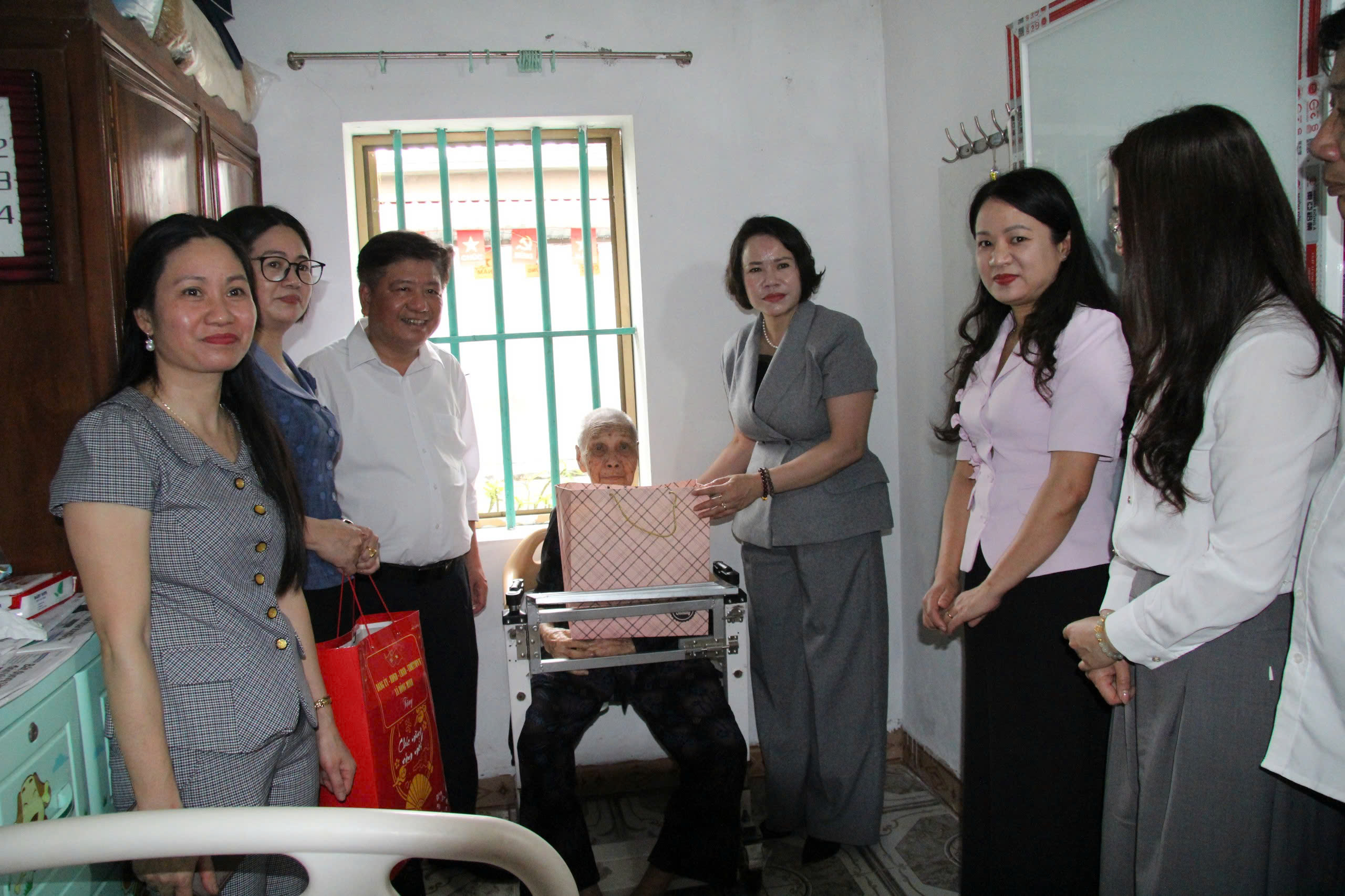 Đồng chí Quách Thị Hương, Ủy viên Ban Thường vụ Tỉnh ủy, Hiệu trưởng Trường Chính trị Nguyễn Văn Linh tặng quà mẹ liệt sĩ  tại thôn Tịnh Xuyên